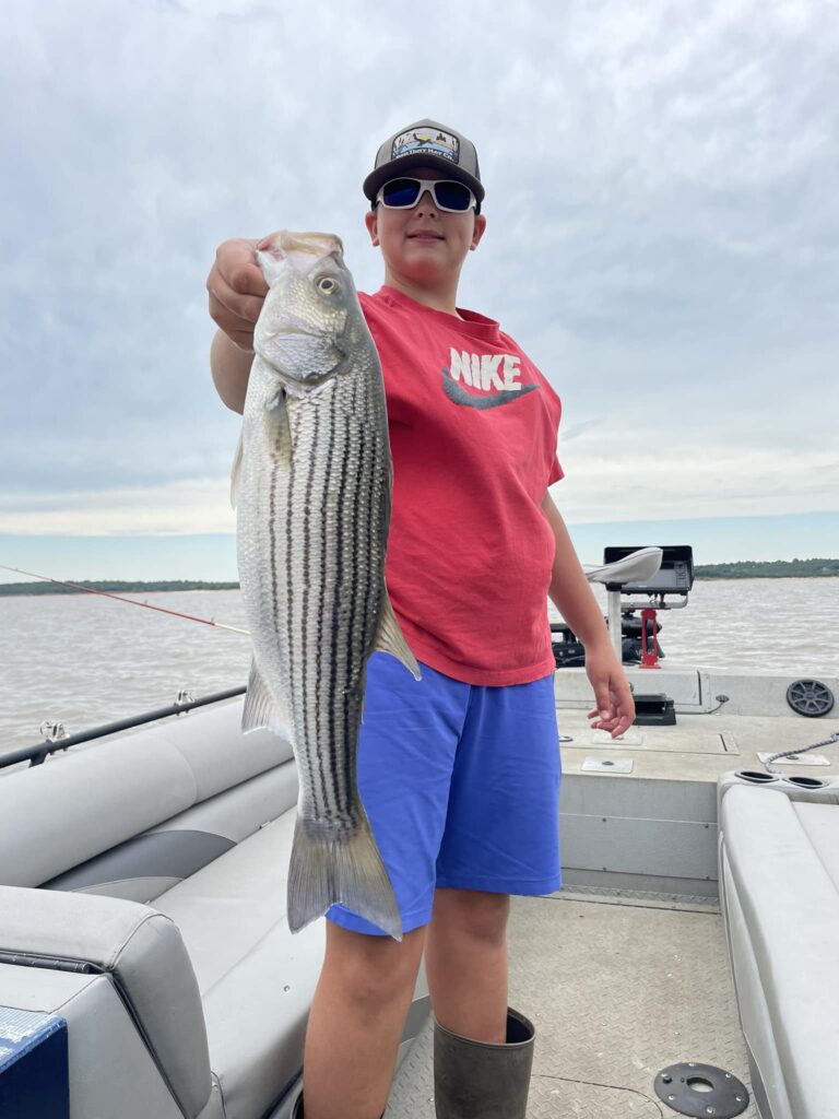 kid in red tshirt holding a fish